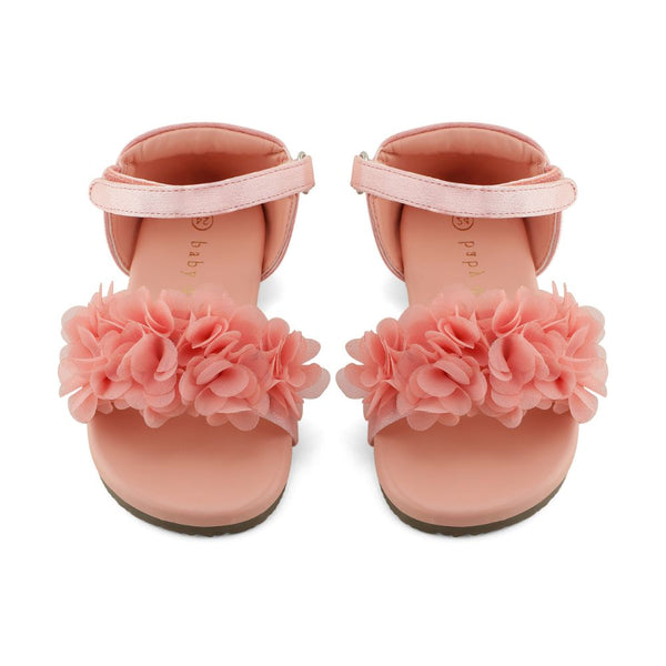Pair of pink sandals with floral decorations on a white background