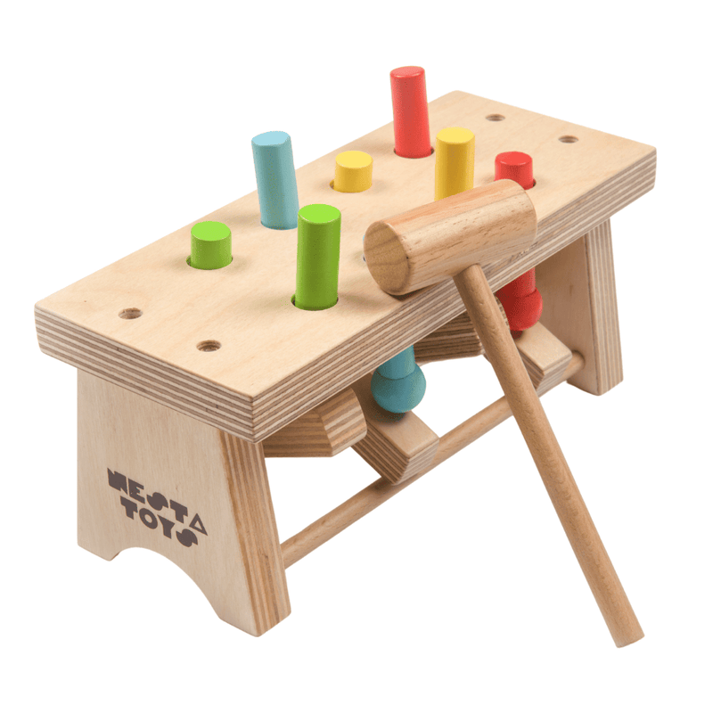 A colorful wooden toy pounding bench with a hammer and various colored pegs.